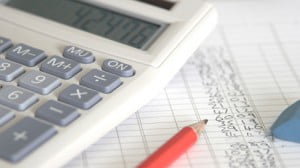 Calculator, pencil and eraser laying on list of figures, close-up